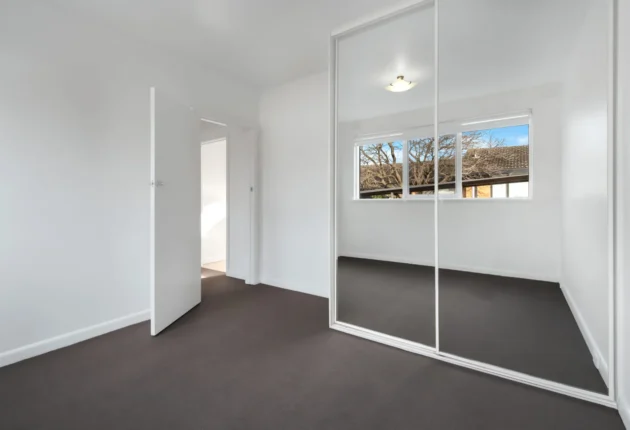 corner-empty-new-room-with-white-walls-wardrobe-with-mirror-sliding-doors-scaled